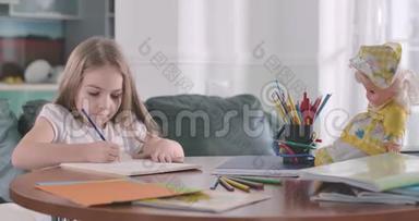 聪明的白人女孩坐在桌子旁做作业。 <strong>练习册</strong>上的孩子写得很集中
